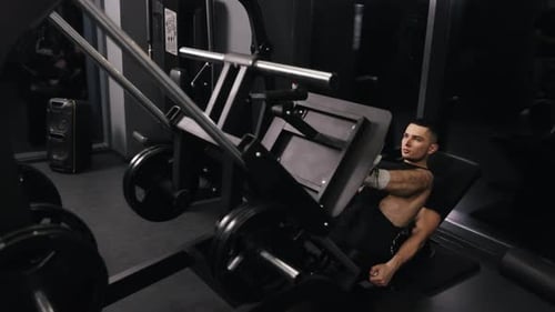 Young Man Leg Pressing in Gym for Fitness