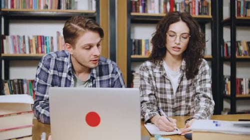 Collaborative Study Session Takes Place in a Cozy Library Setting with Students Focused on Their