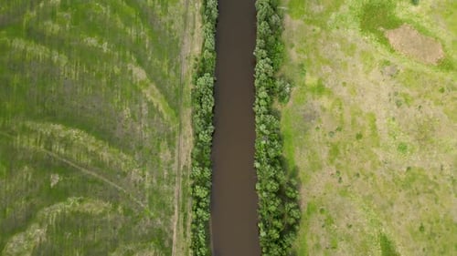 Aerial Drone Shot Flying Above the River Canal and Field in Countryside at Sunrise