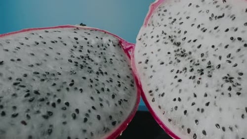 Two slices of dragon fruit (Pitaya) with blue background. slider zoom in with probe lens.