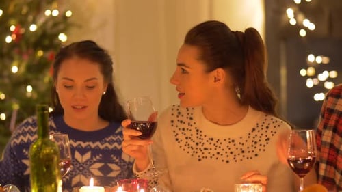 Friends Enjoying Wine at Cozy Christmas Dinner Party