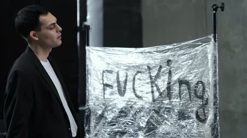 young male Tatar writes the word "fucking" with a brush on a banner