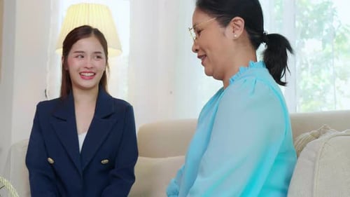 Women Chatting Together on Sofa Indoors
