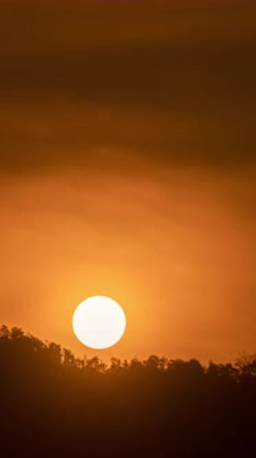 Timelapse of dramatic sunrise with orange sky in a sunny day.