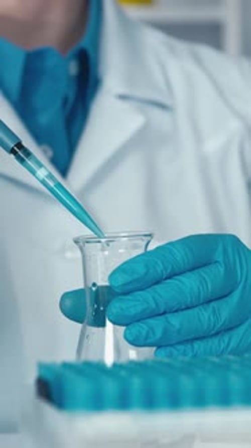 Scientist Working with Test Tubes and Beaker in Lab