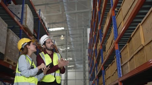 Blue collar workers are working at warehouse.