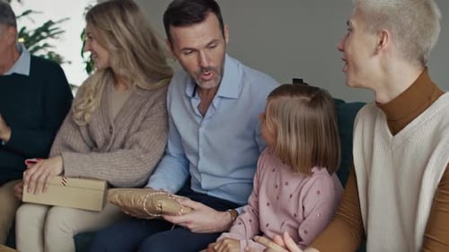 Family Celebrates Christmas, Giving Gifts