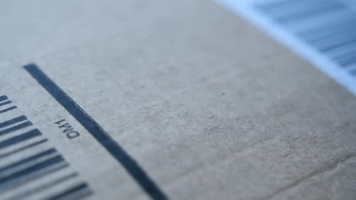 Hand Applying Label to Brown Shipping Package