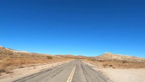 Driving through the arid landscape of the Mojave Desert - driver Point of view hyper lapse