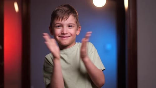 Smiling Boy Clapping Hands Enthusiastically Indoors