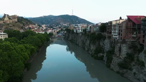 Flying Over Mtkvari River With Metekhi Cliff In Tbilisi, Georgia. - aerial