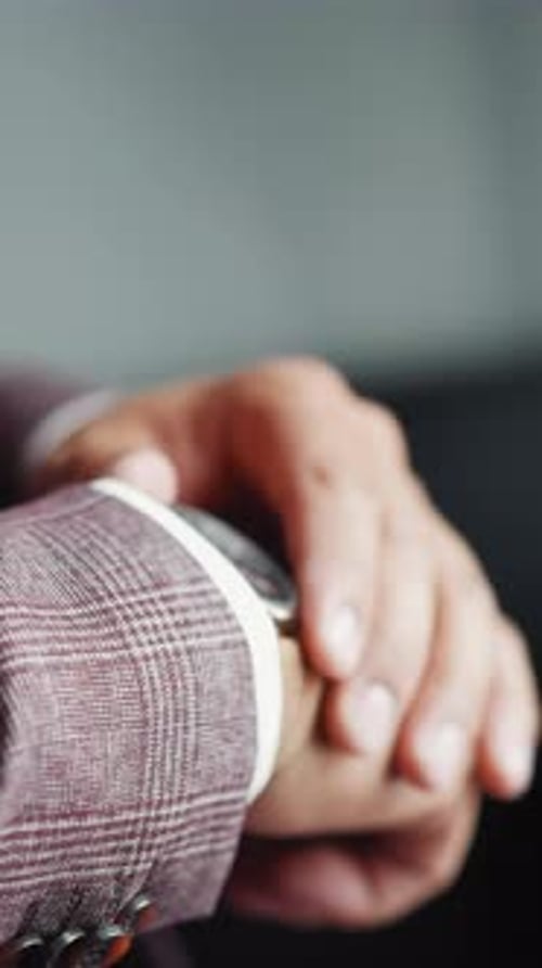 Man in Suit Checking Watch Closely