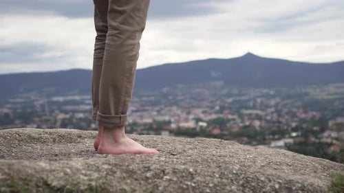 Closeup of male barefoot feet walking and standing on rock outside, nice background of nature and ci