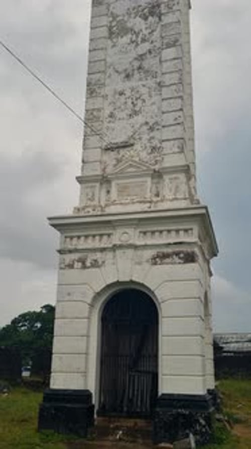 Vue verticale de la tour de l'horloge du fort de Matara au Sri Lanka s'élevant sur un ciel nuageux et pluvieux, surligné