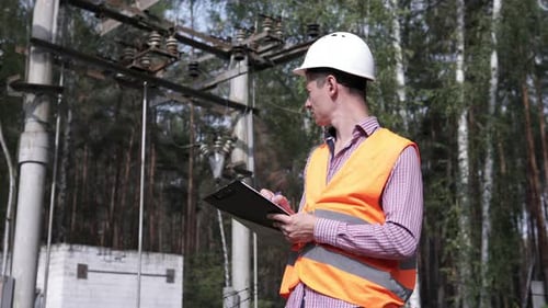 An employee of the energy structure inspects energy equipment and power lines.