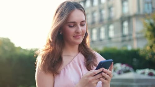 Young Caucasian Woman Walking in City and Texting on Smartphone Joyful Caucasian Female Use