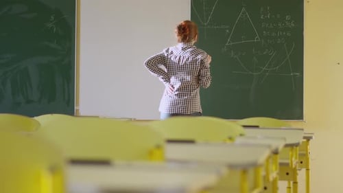 A Girl Student Writes on a Green Board