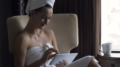 Woman in Towel Relaxing with Tablet Indoors