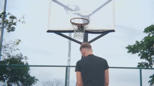 close-up back basketball player throws the ball into the basketball hoop