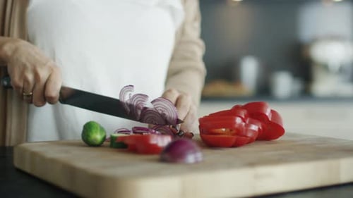 Close-up Shot Showing Delicate Woman Hands Cutting Vegetables on the Kitchen Table.