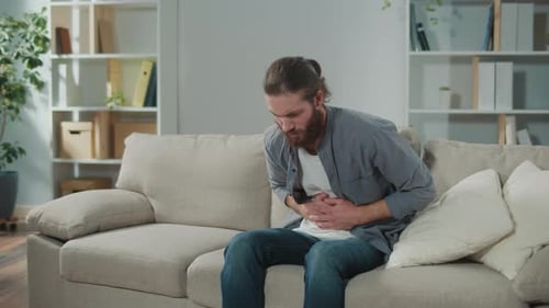 Man Suffering from Stomach Pain on Couch