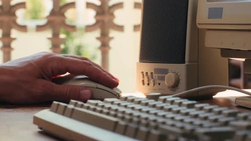Hombre trabajando y jugando en una computadora retro, ingeniero de TI con una computadora antigua en casa usando una vieja