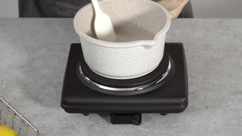 Liquid being Poured and Stirred in Pot