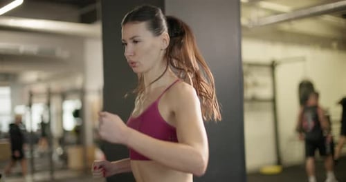 A Young Beautiful Brunette Girl in Sportswear Exercises on a Simulator in the Gym Doing Cardio