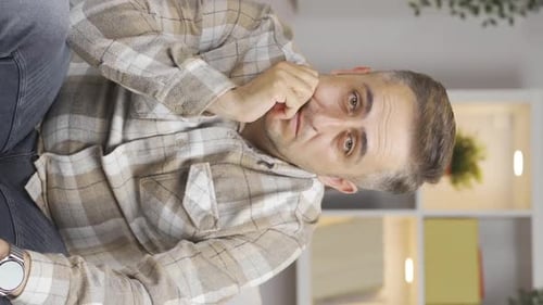 Vertical video of Man looking thoughtfully at camera.