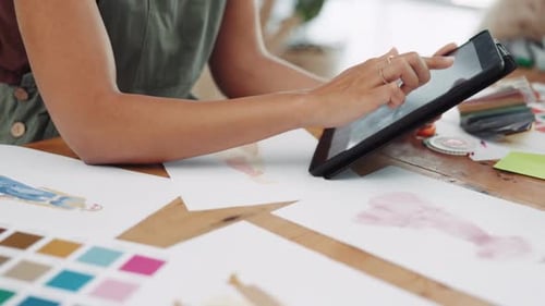 Young Adult Fashion Designer Works on Tablet