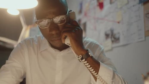 Détective parlant au téléphone au travail pendant la nuit