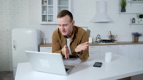 Man Talking on Video Call on Laptop in Kitchen