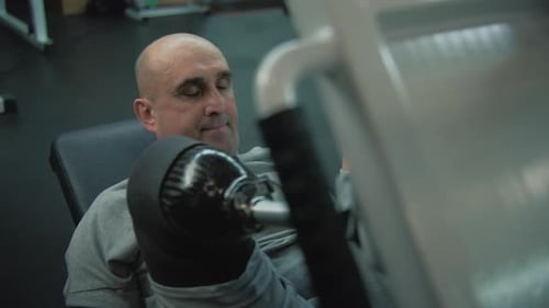Athlete with Prosthesis on Leg Trains on Leg Press Machine in Fitness Center