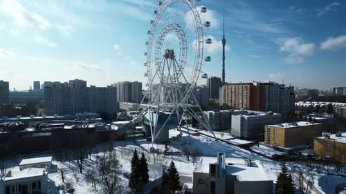 Top view of Ferris wheel in city center in winter. Creative. Large Ferris wheel stands in city