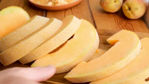 Les mains de plusieurs personnes saisissent des tranches de melon mûr et juteux sur la table, des fruits frais et sucrés prêts à manger