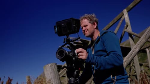 Cameraman Setting Up Professional Equipment Outdoors