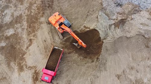 Excavator Loading Soil into Dump Truck from Above