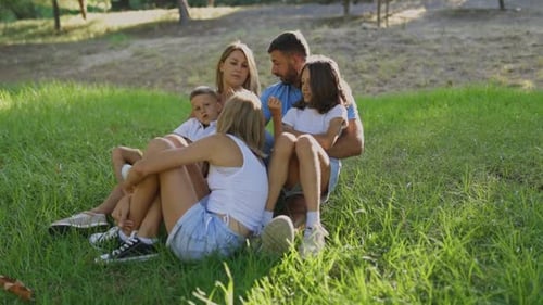 Happy Family Relaxing Together in a Green Park