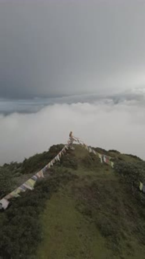 Vidéo aérienne de nuages en arrière-plan d'un homme debout sur un pic au Népal