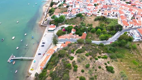 aerial view over small coastal town, blue ocean, red roofs, 4k