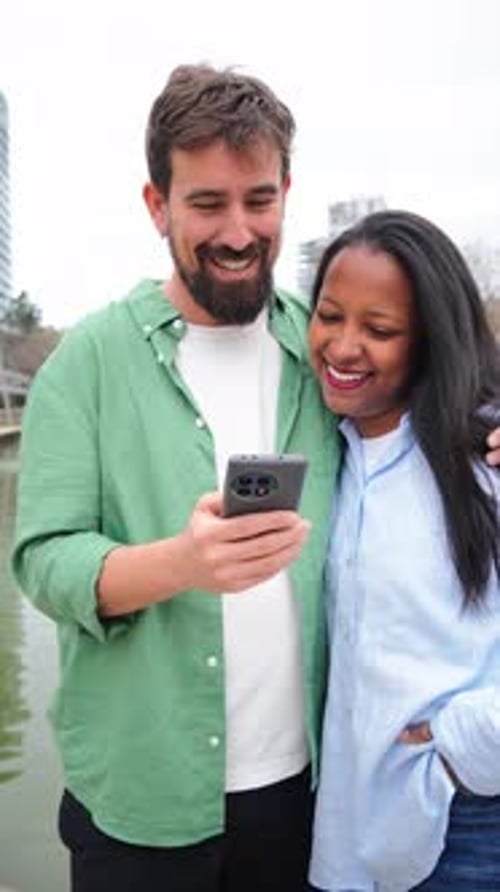 Happy Couple Looking at Phone Outside