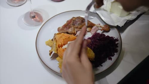 Cutting a Holiday Dinner of Meat and Sweet Potato