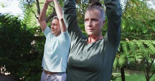 Relaxed senior caucasian couple happy practicing yoga together sitting in garden