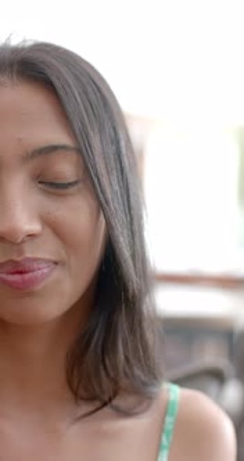 Vidéo verticale : Une jeune femme caucasienne sourit chaleureusement, les yeux brillants