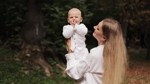 Beautiful Mother Holds Up Baby In The Woods