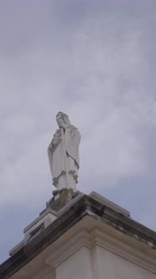 Statue Standing Tall Under Cloudy Skies
