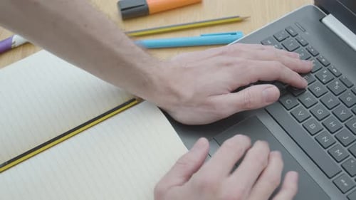 Travailler à domicile en utilisant un ordinateur portable, un trackpad, une souris sur la table à manger en gros plan avec un bloc-notes et des stylos