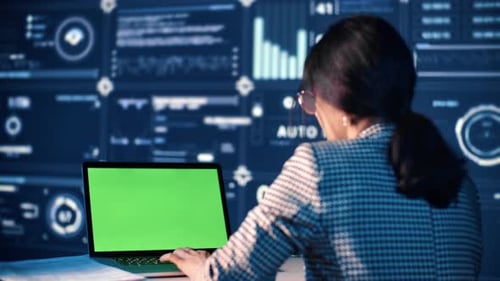 Mixedrace IT-Expertin arbeitet mit modernem PC mit Greenscreen für Chroma-Key-Technologie