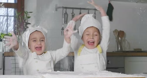 Two little girls in the kitchen prepare food, a dessert for the family. As they learn to cook they