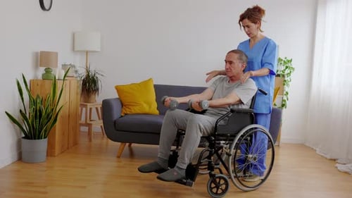 Caregiver Assists Senior Man with Dumbbell Exercises at Home
